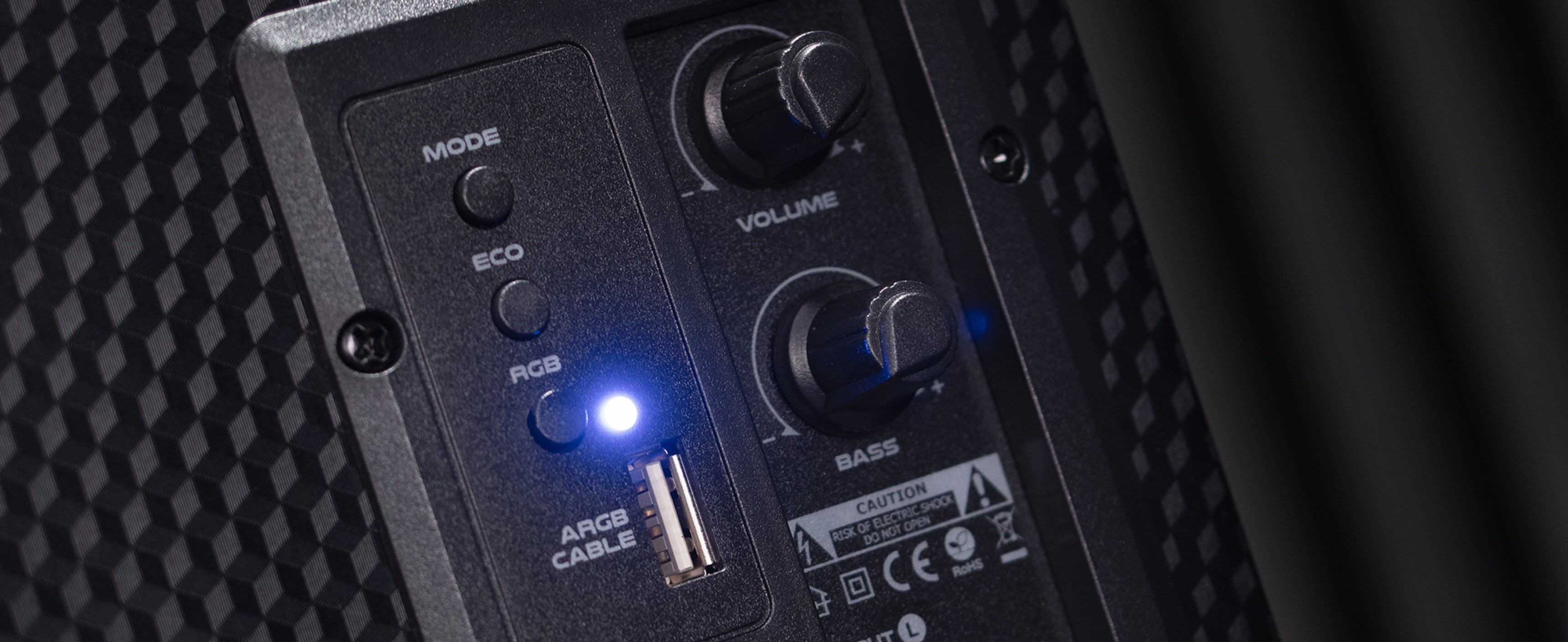 Control panel of Genesis Helium 300BT Bluetooth speakers featuring volume, bass, and RGB mode buttons with indicator light