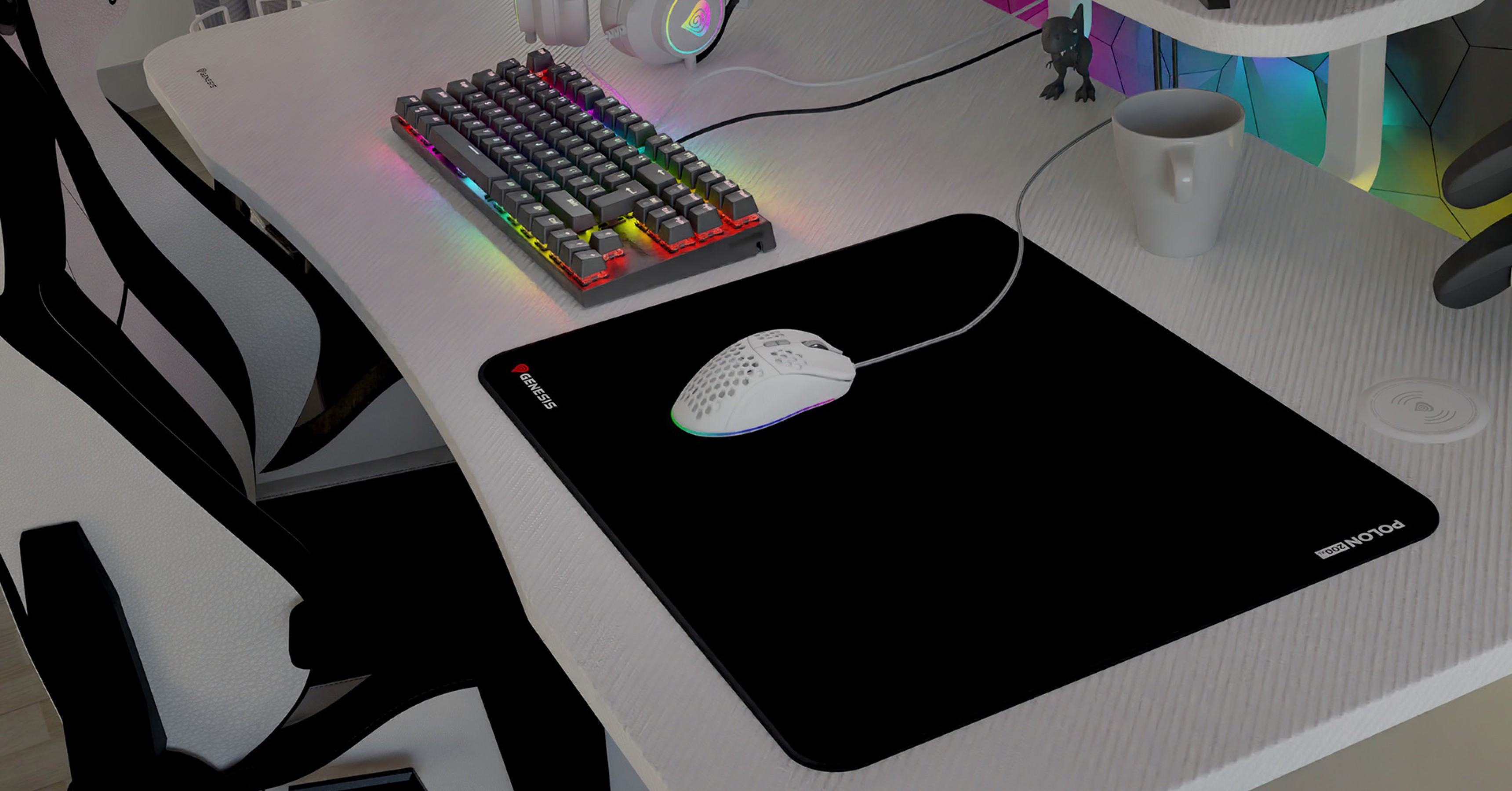 Black gaming mouse pad with a white gaming mouse, placed on a desk alongside a colorful keyboard and a cup