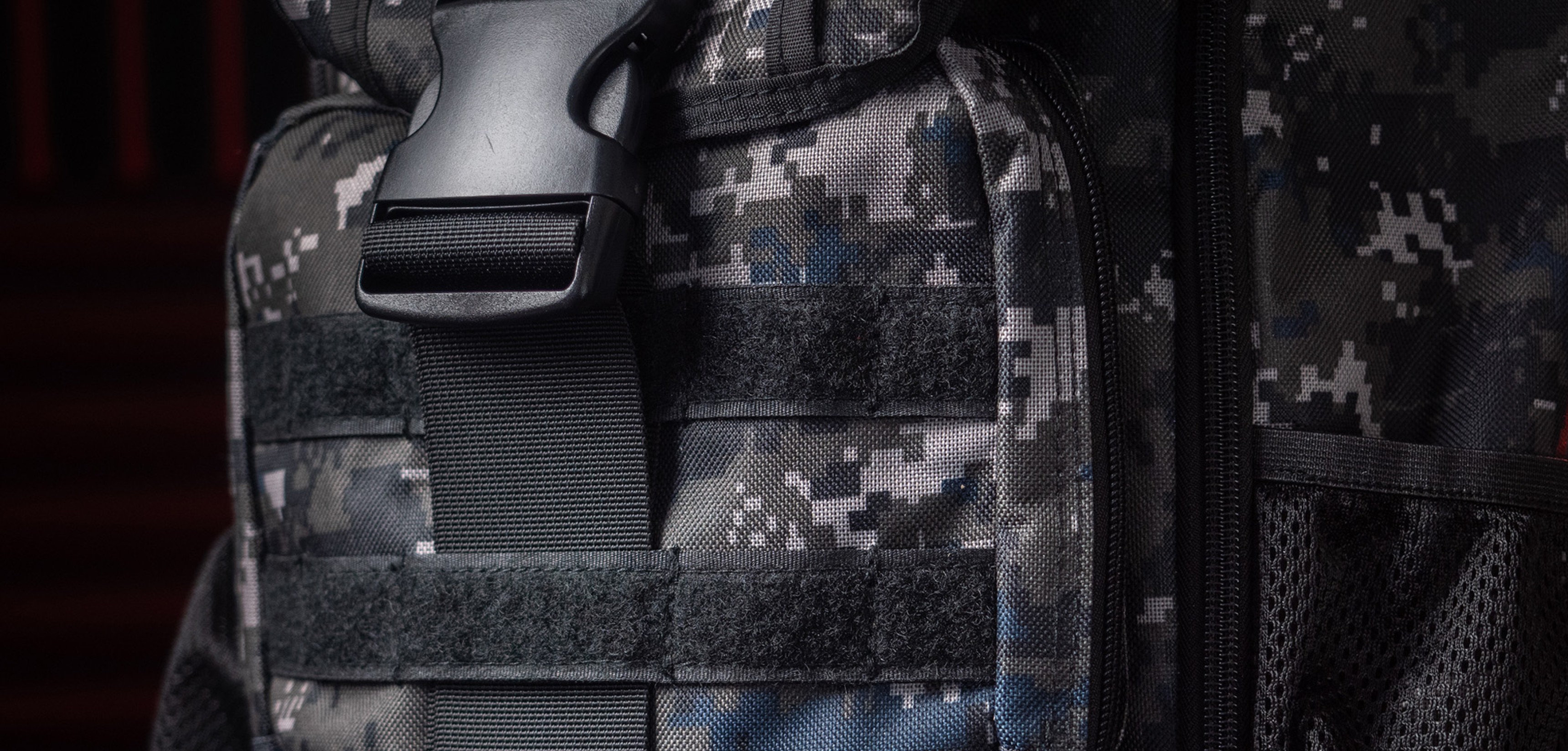 Close-up of the Genesis Pallad 450 Camo Lite laptop backpack, featuring a camouflage pattern and secure buckle