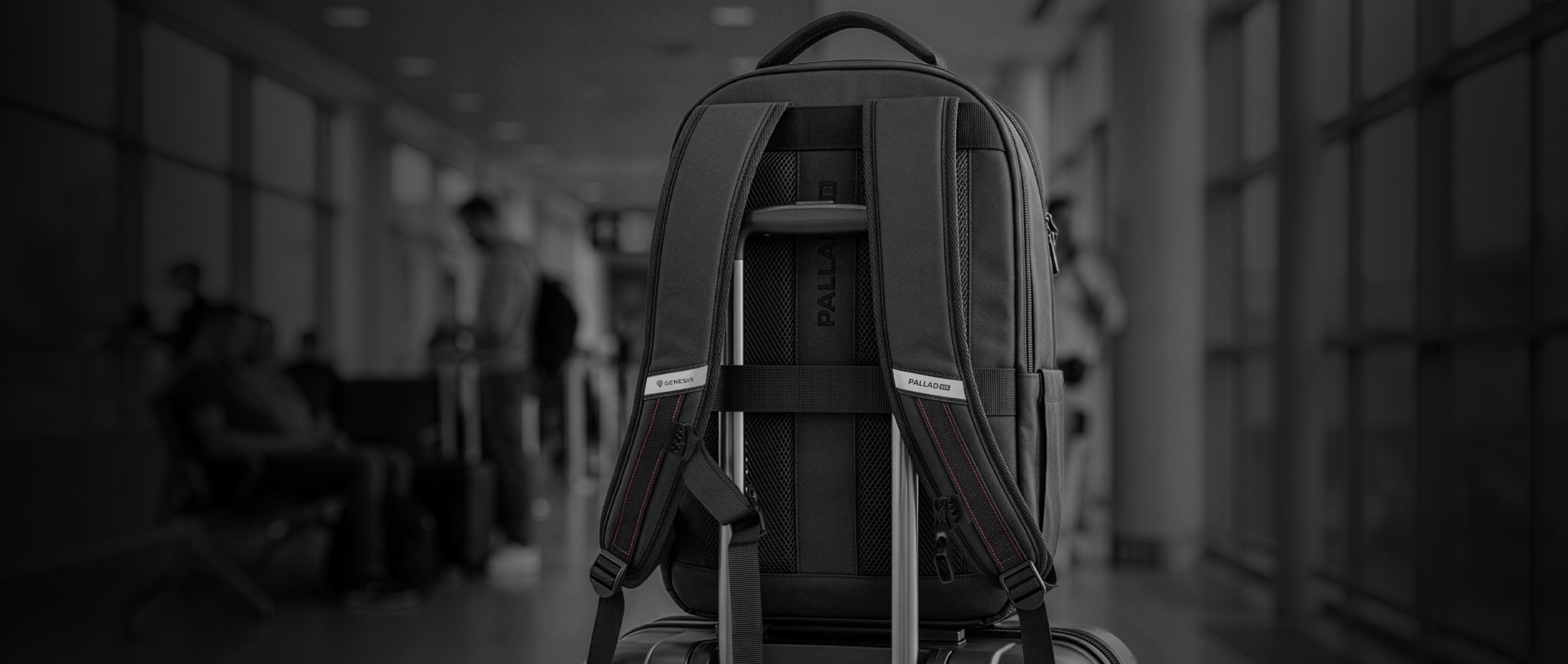 A backpack resting on a wheeled suitcase in a busy airport terminal.
