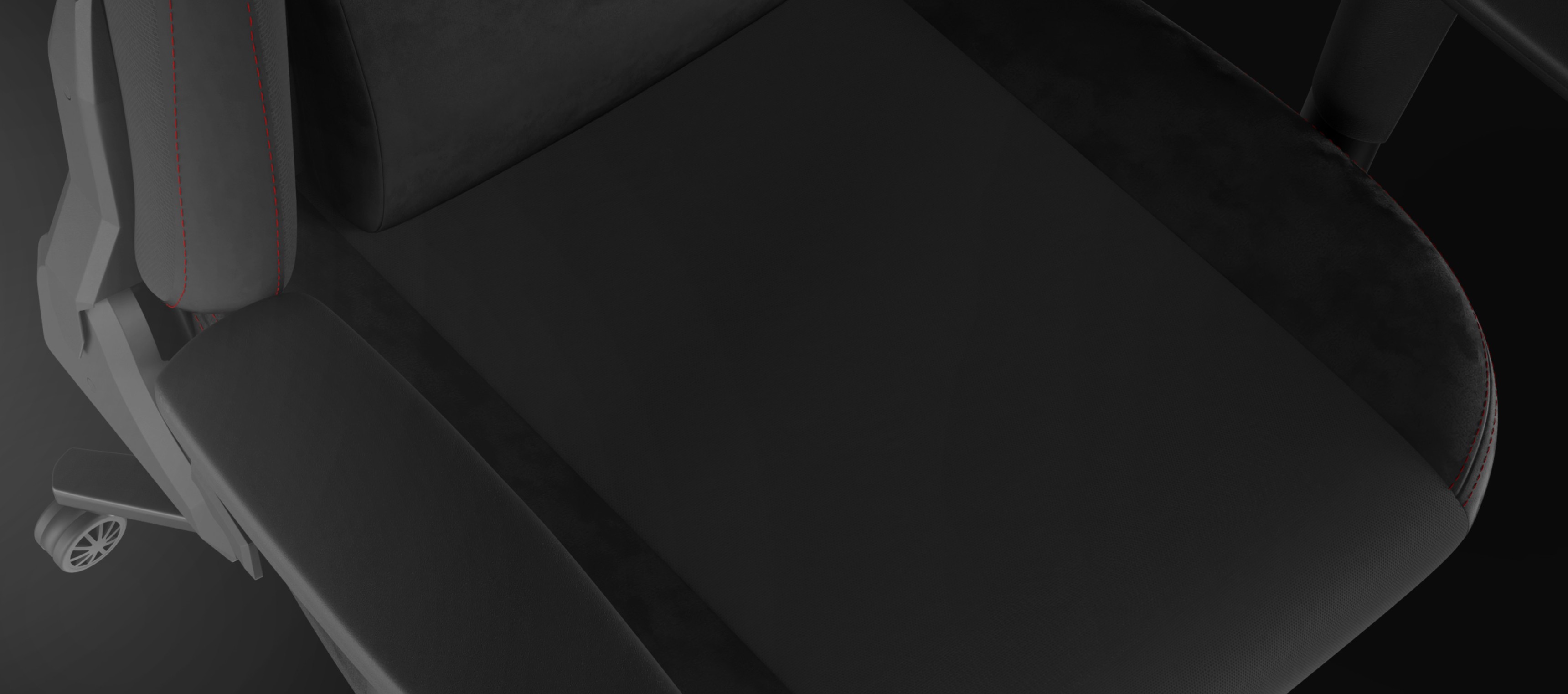 Close-up view of a gaming chair with sleek black fabric and red stitching accents.