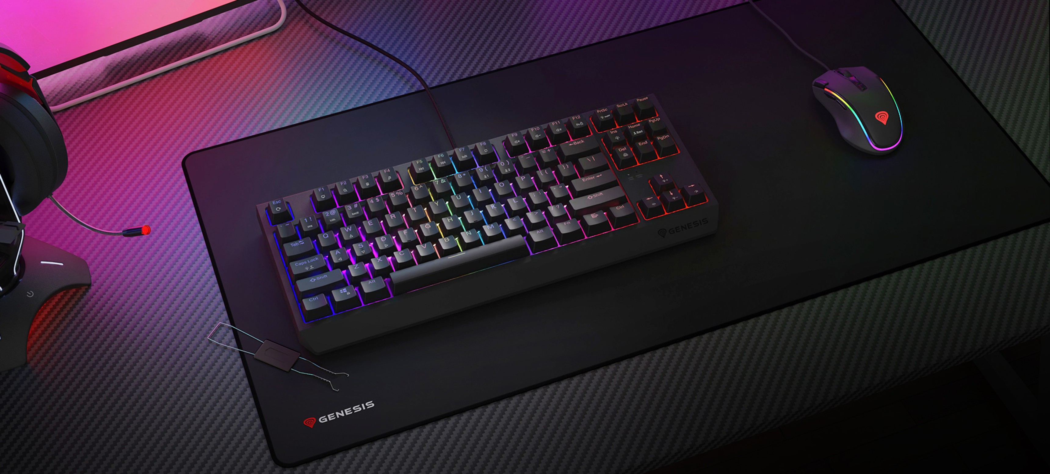 Mechanical gaming keyboard with RGB lighting on a gaming mouse pad, accompanied by a gaming mouse and headset