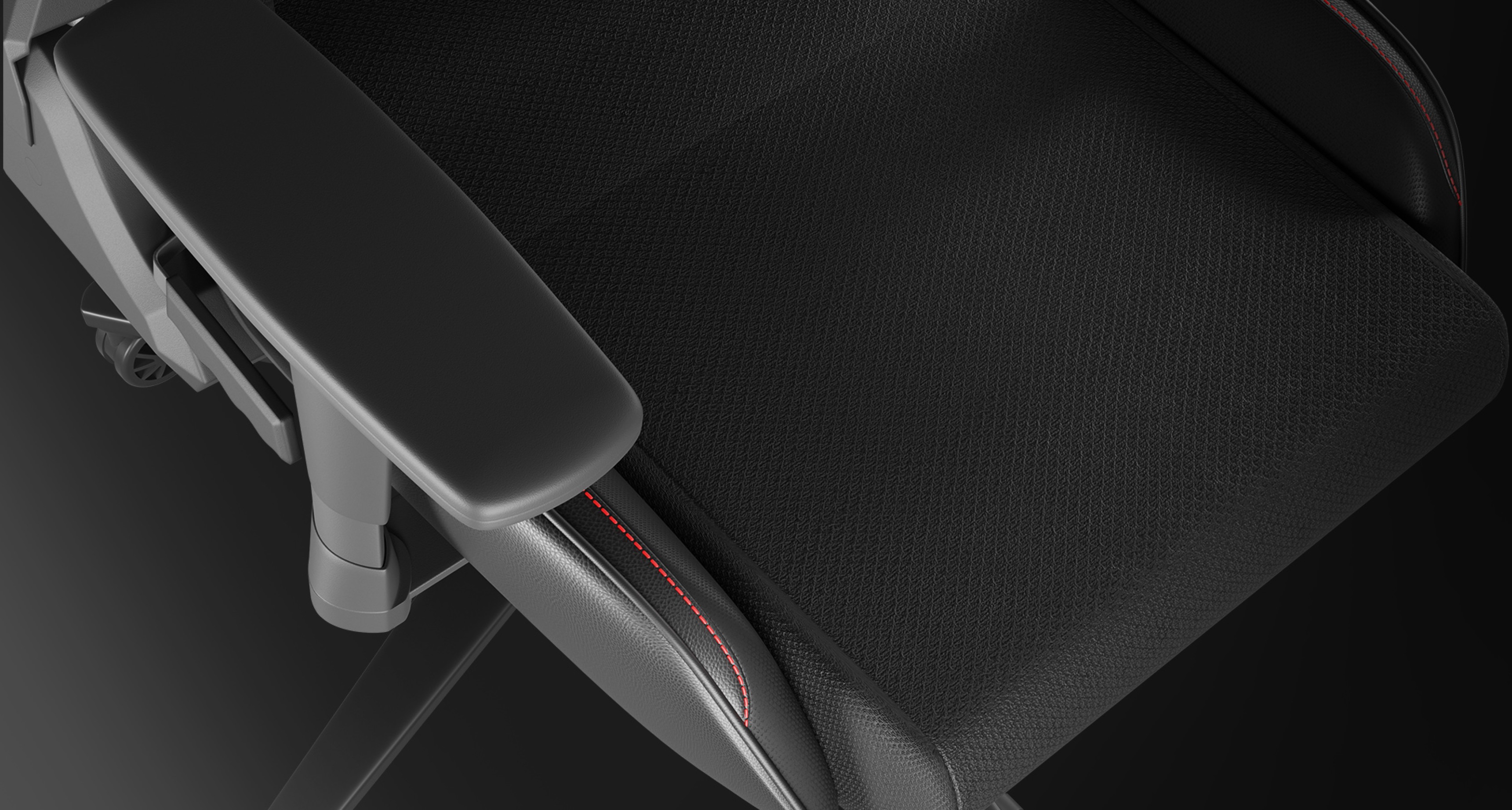 Close-up view of the Genesis Nitro 550 G2 gaming chair, featuring a black textured seat and armrest with red stitching accents