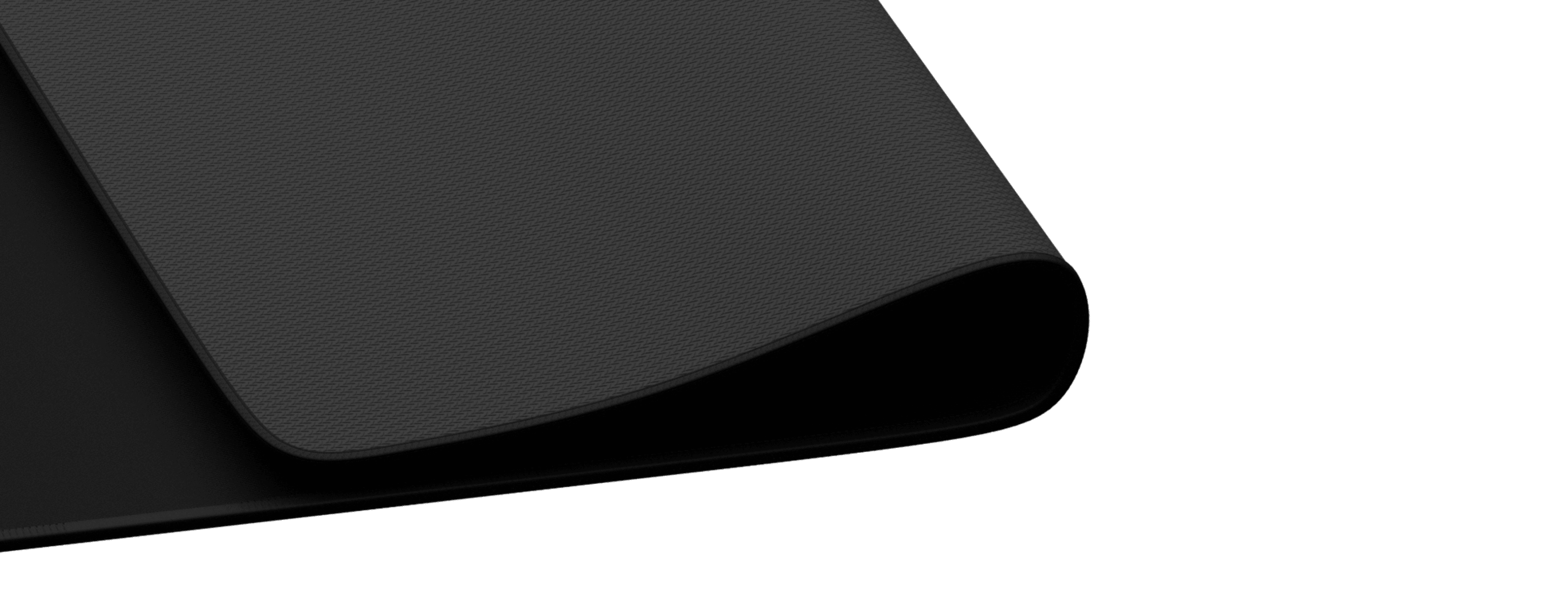 Close-up of a black Genesis Carbon 700 XL mouse pad with a textured surface and slightly curled edges