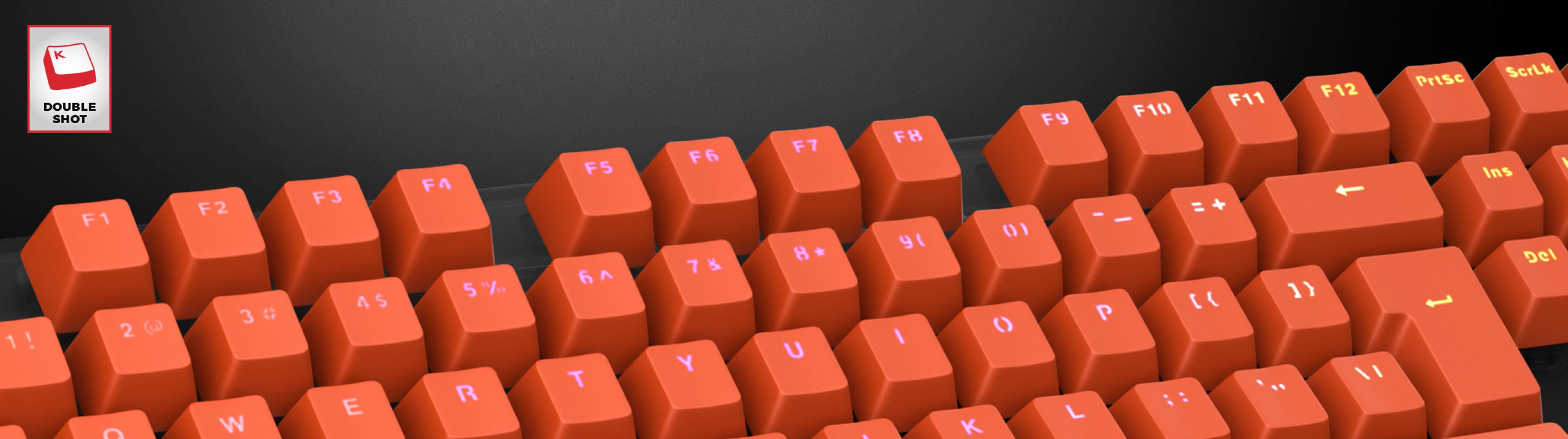 Bright orange double-shot keycaps arranged on a keyboard, featuring clear lettering on each key