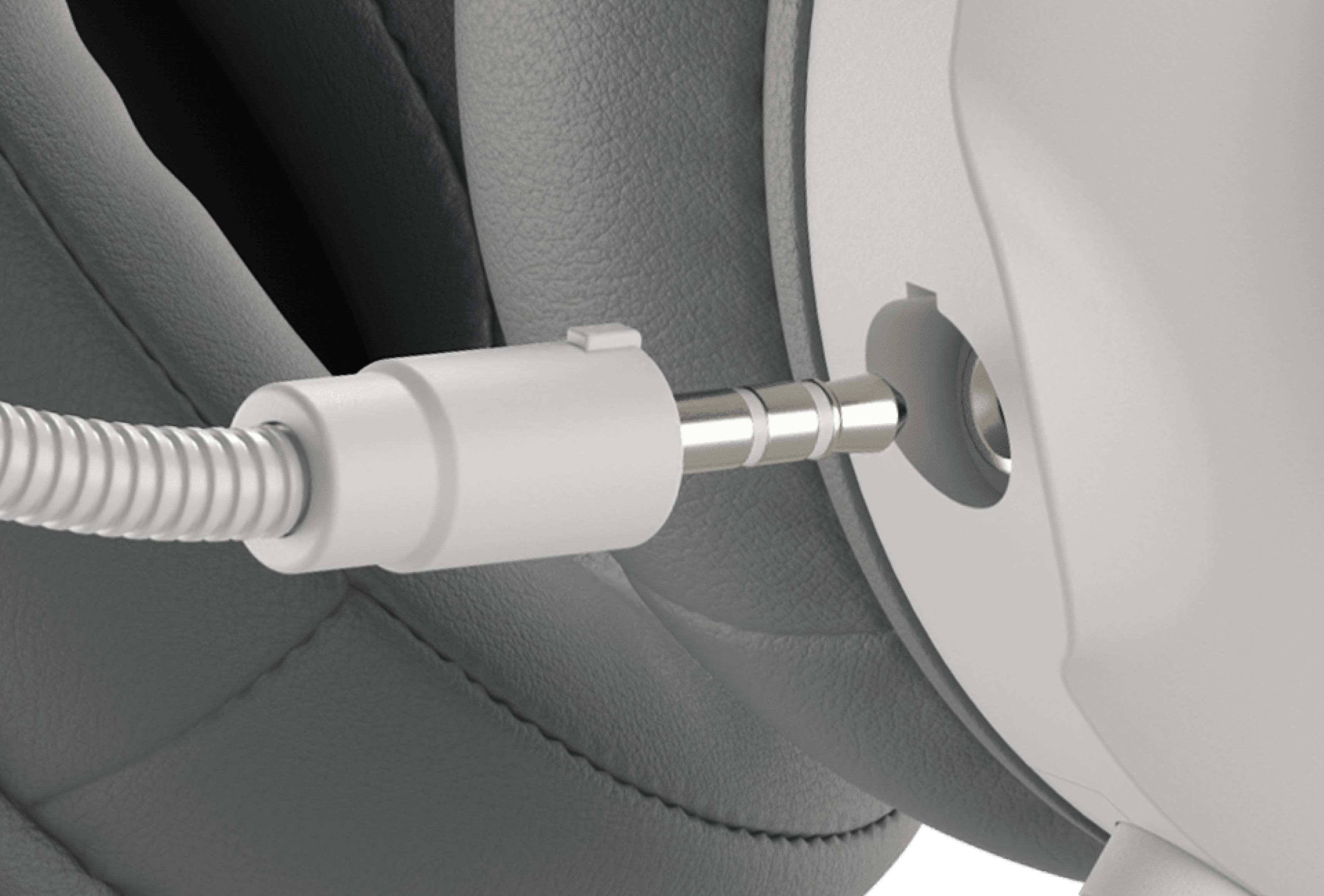 Headphone connected with a cable to a round audio input jack.