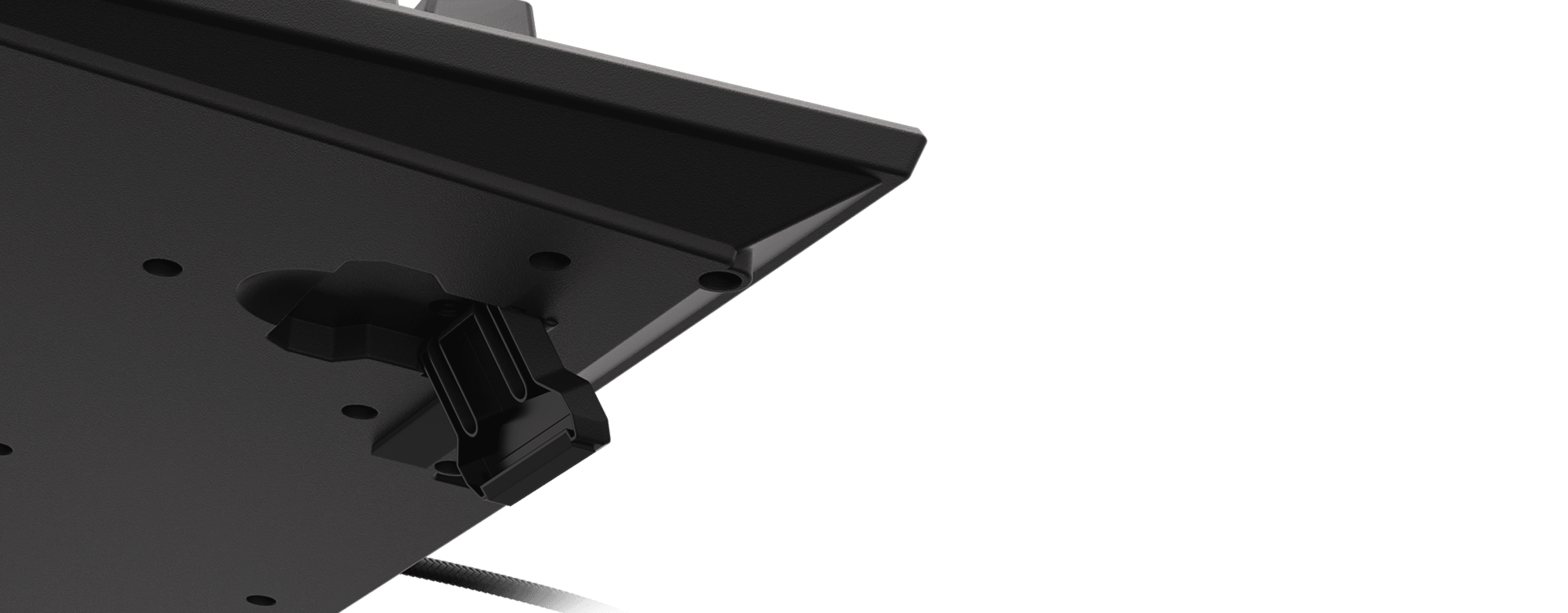 Close-up view of a black surface with a mounting bracket and a cable.