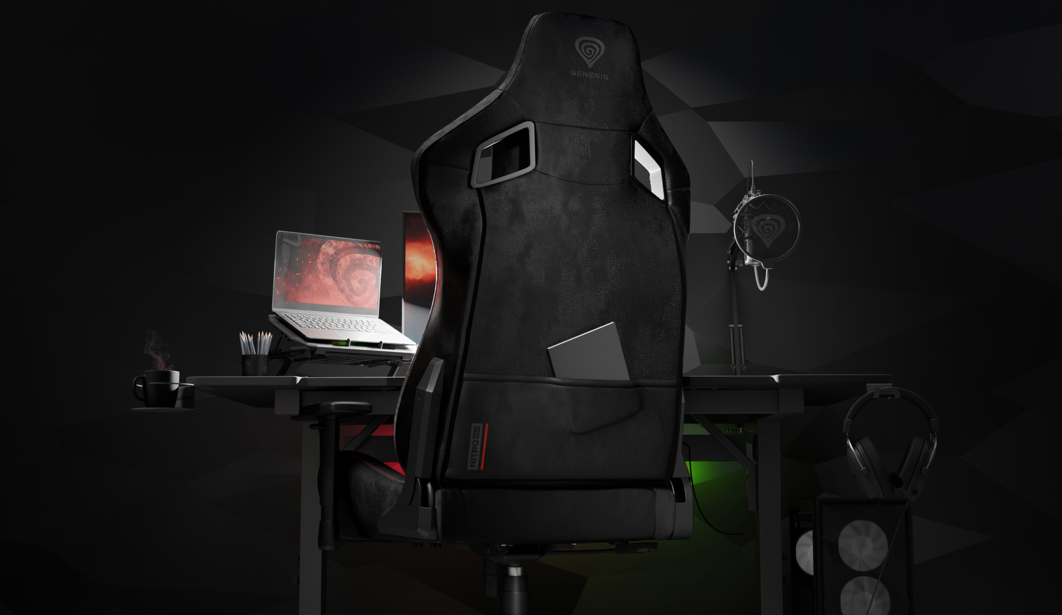 Gaming chair positioned in front of a desk with a laptop and small fan.