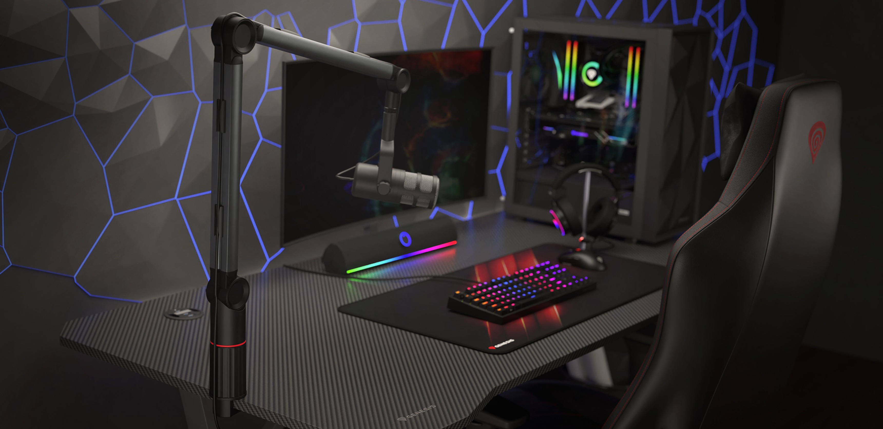 Microphone arm installed on a gaming desk with a colorful keyboard, gaming chair, and a computer tower in the background