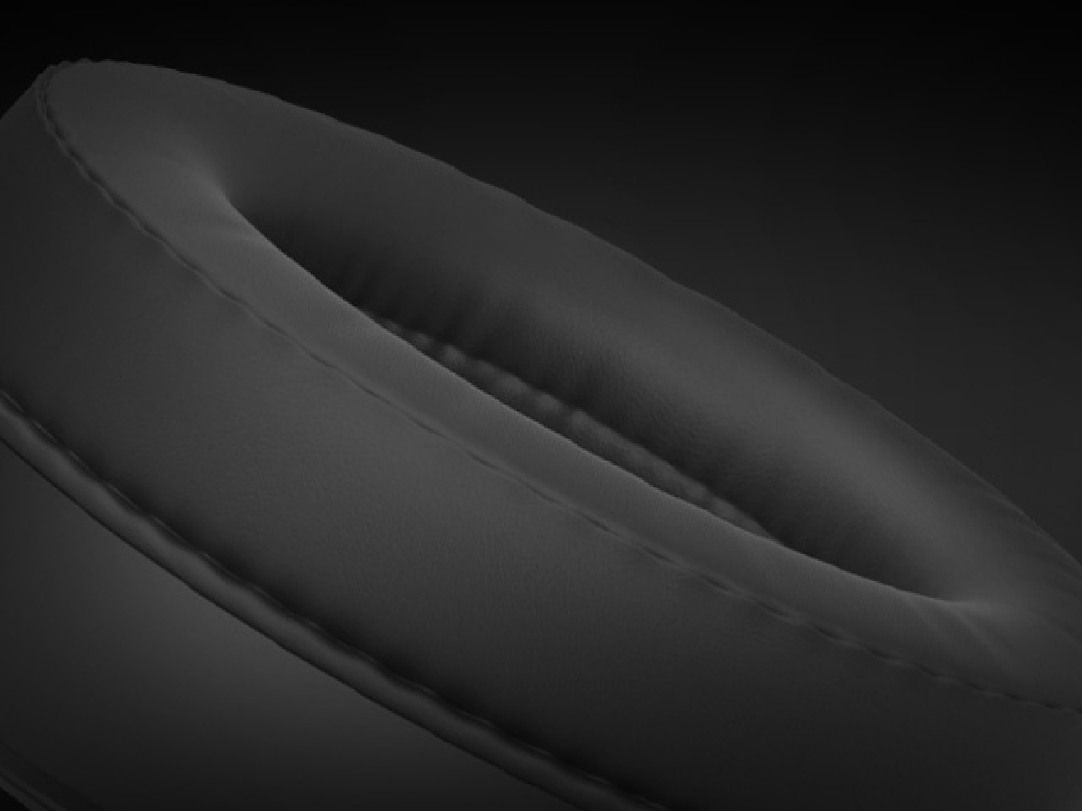 Close-up of a soft, padded headphone ear cushion in black color with visible stitching.