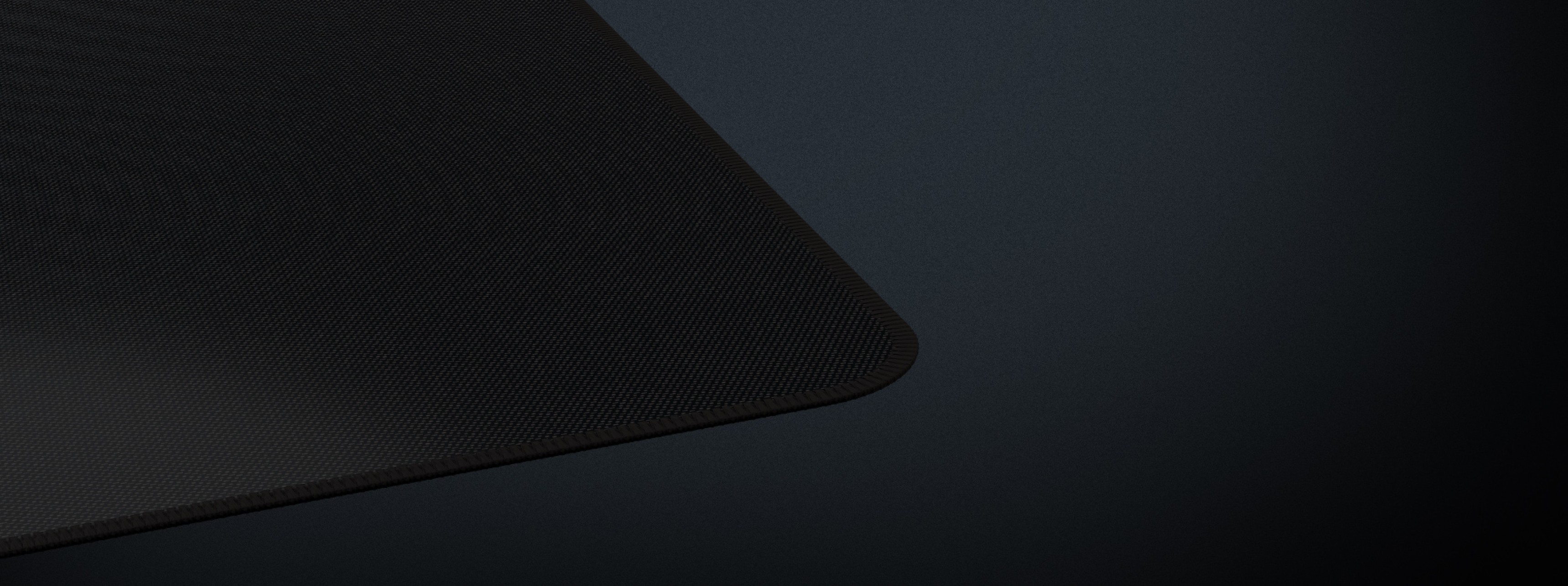 Black gaming mouse pad with a textured surface and rounded edges, measuring 1100x450mm