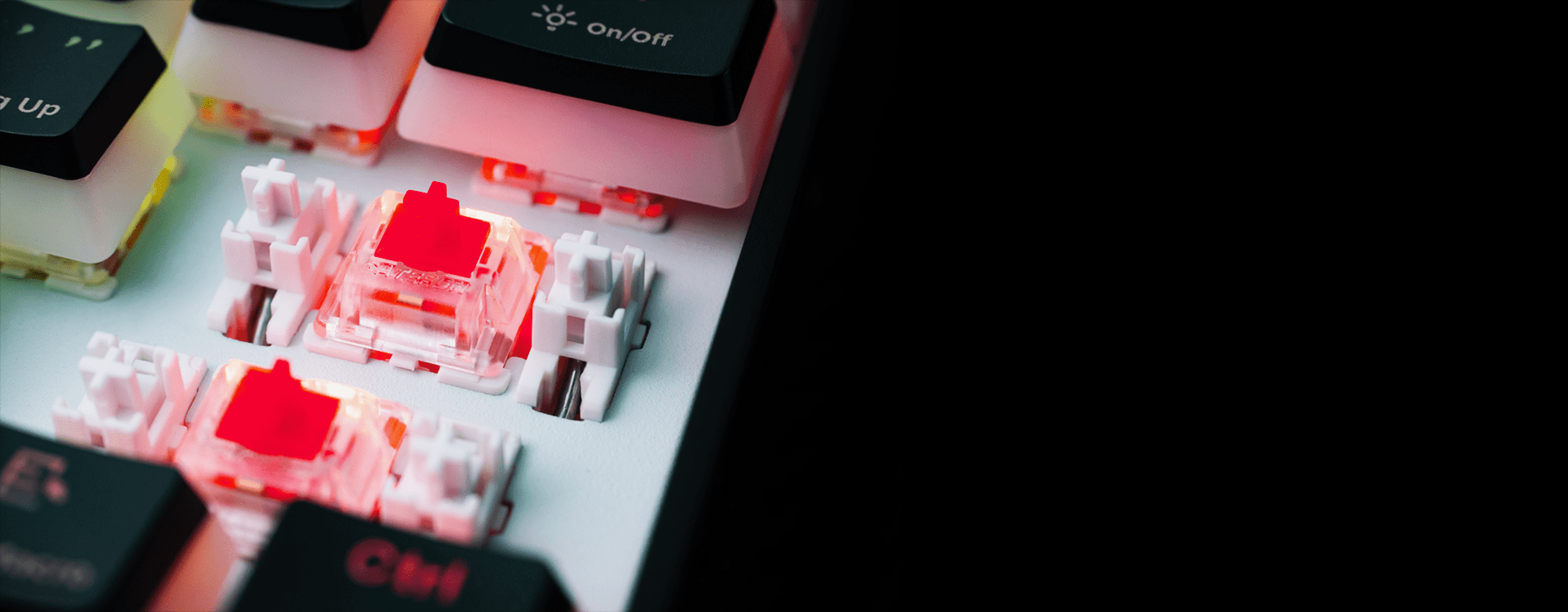 Close-up of keyboard switches with glowing red lights and keycaps partially removed.