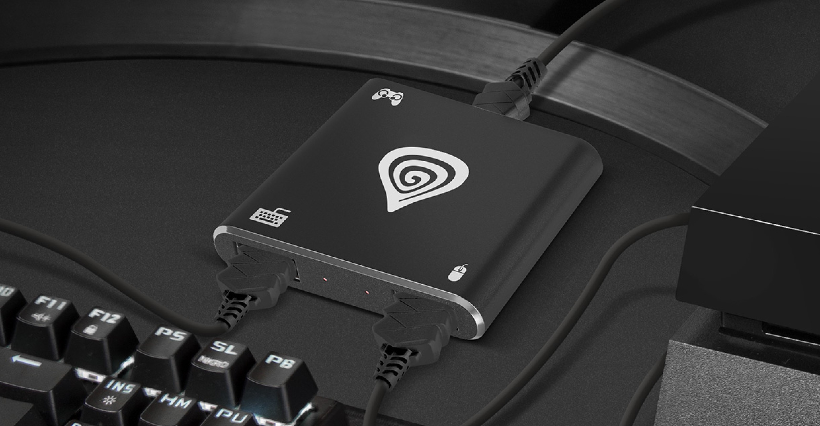 Device with multiple connection ports placed on a desk next to a gaming keyboard.