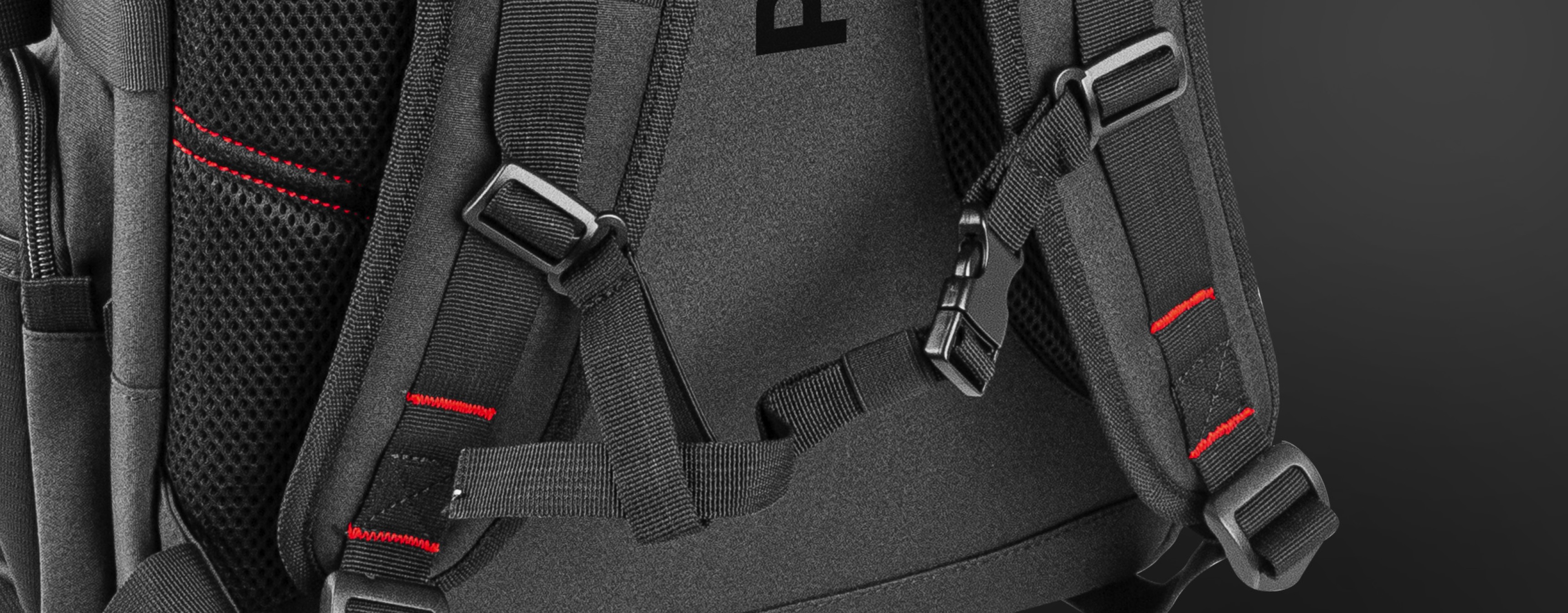 Close-up of the Genesis Pallad 550 laptop backpack features adjustable straps and reflective detailing on a black surface