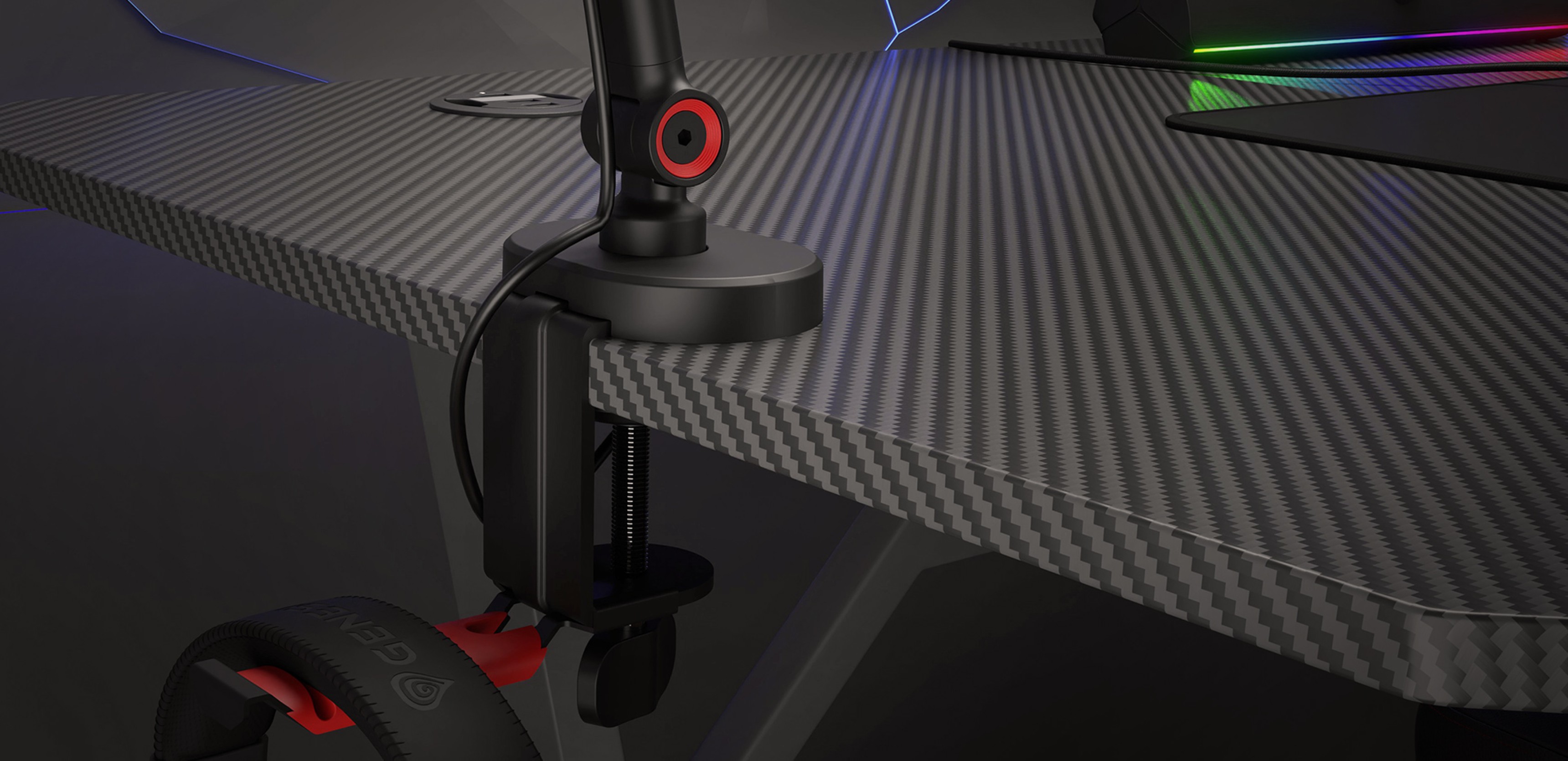 Microphone arm attached to a gaming desk with a headset holder, featuring a sleek black design and red accents