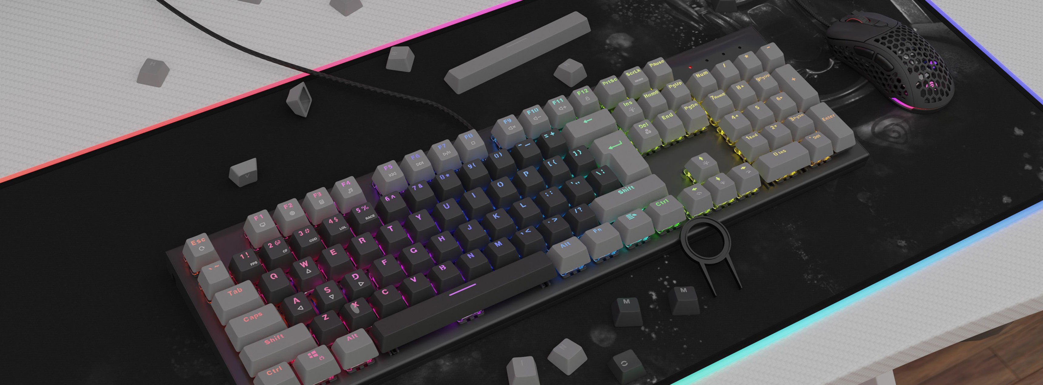 A mechanical keyboard with colorful RGB lighting and gray double shot keycaps, placed on a textured mousepad