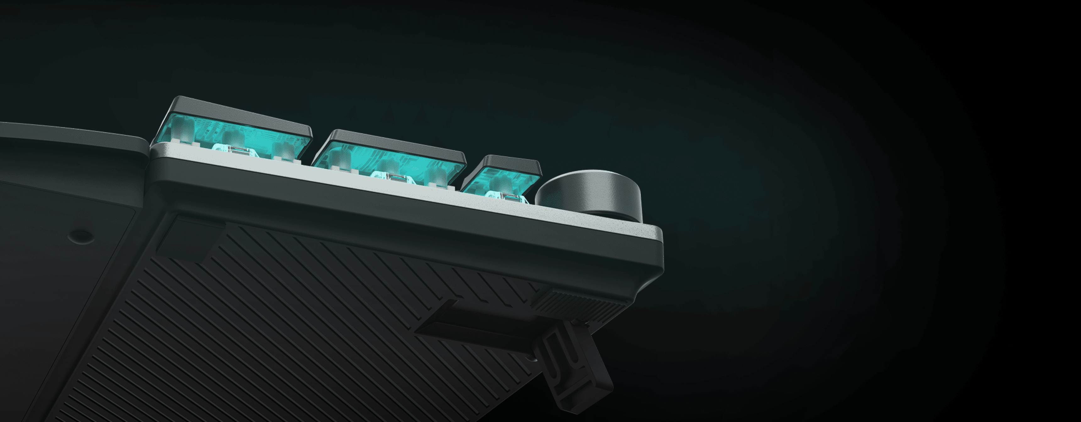 Keyboard corner showing illuminated keys and a volume control knob.