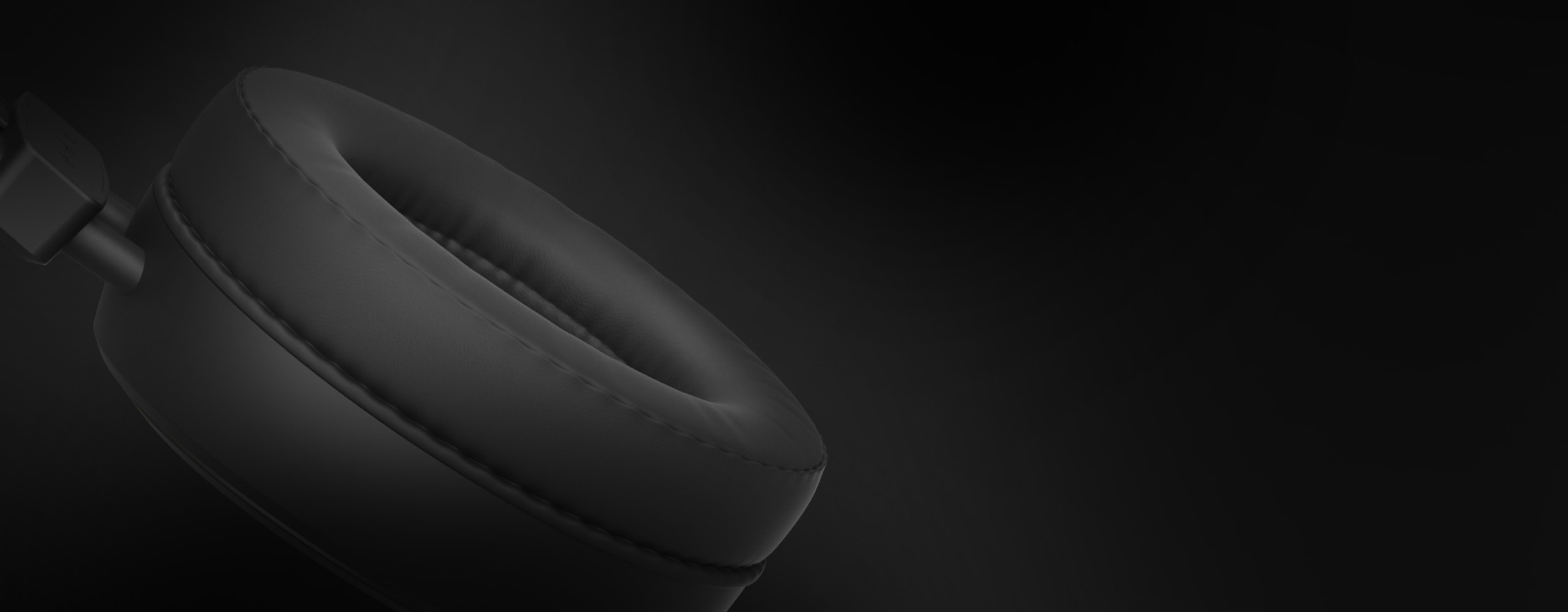 Black circular headphone ear cushion against a dark background with soft texture.