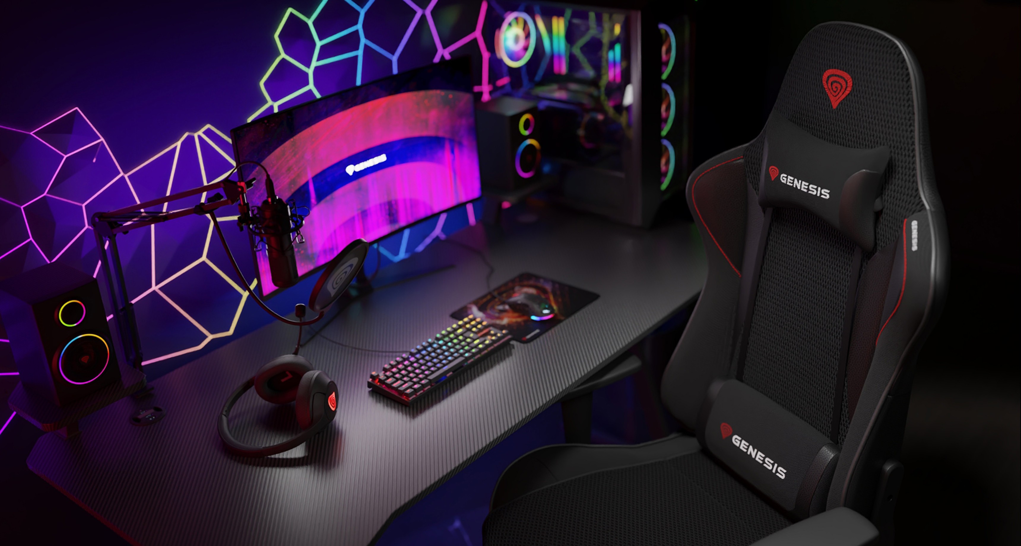 Black Genesis Nitro 440 G2 mesh gaming chair positioned beside a sleek gaming setup with a vibrant monitor and RGB peripherals