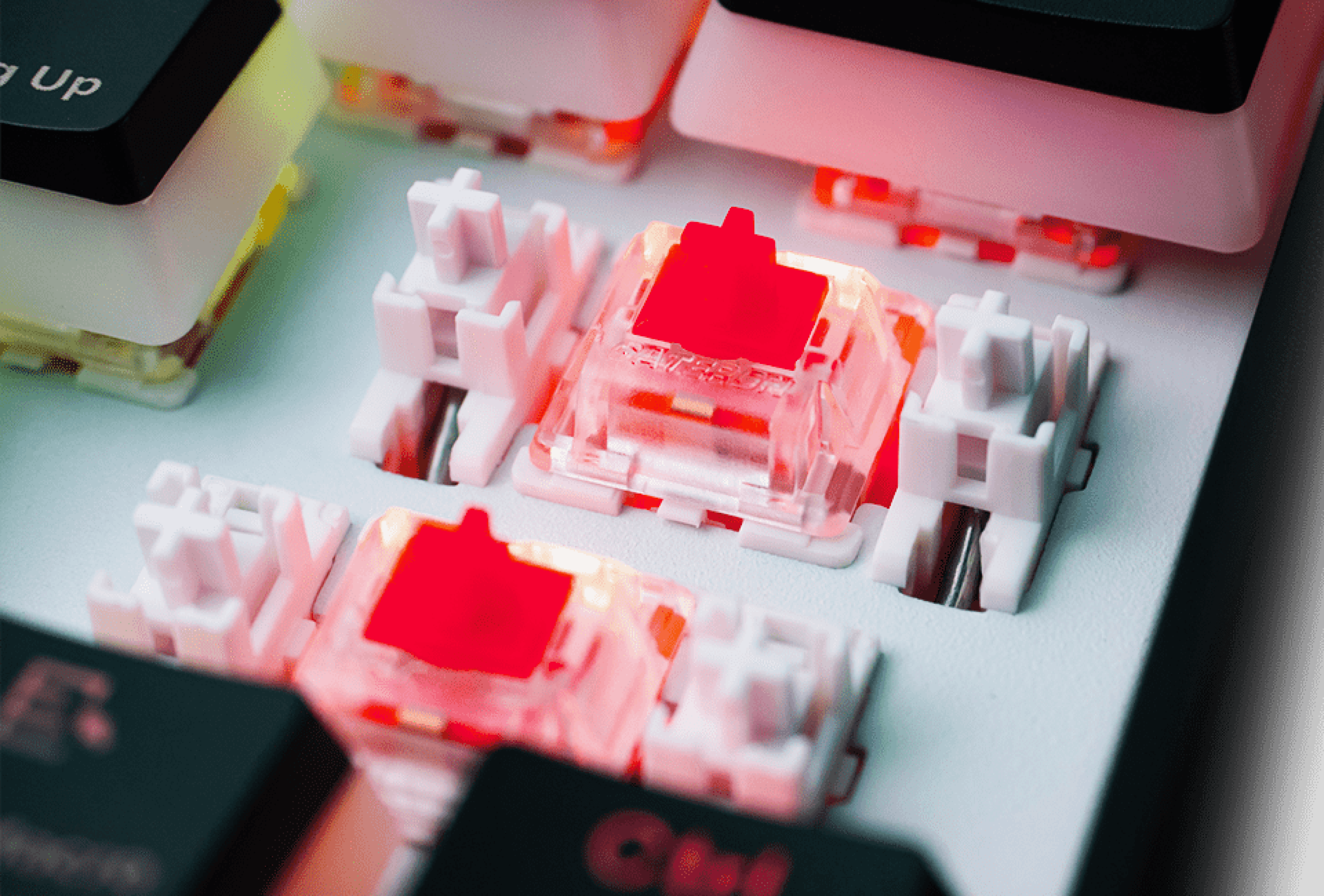 Close-up of keyboard switches illuminated in red with keycaps removed.