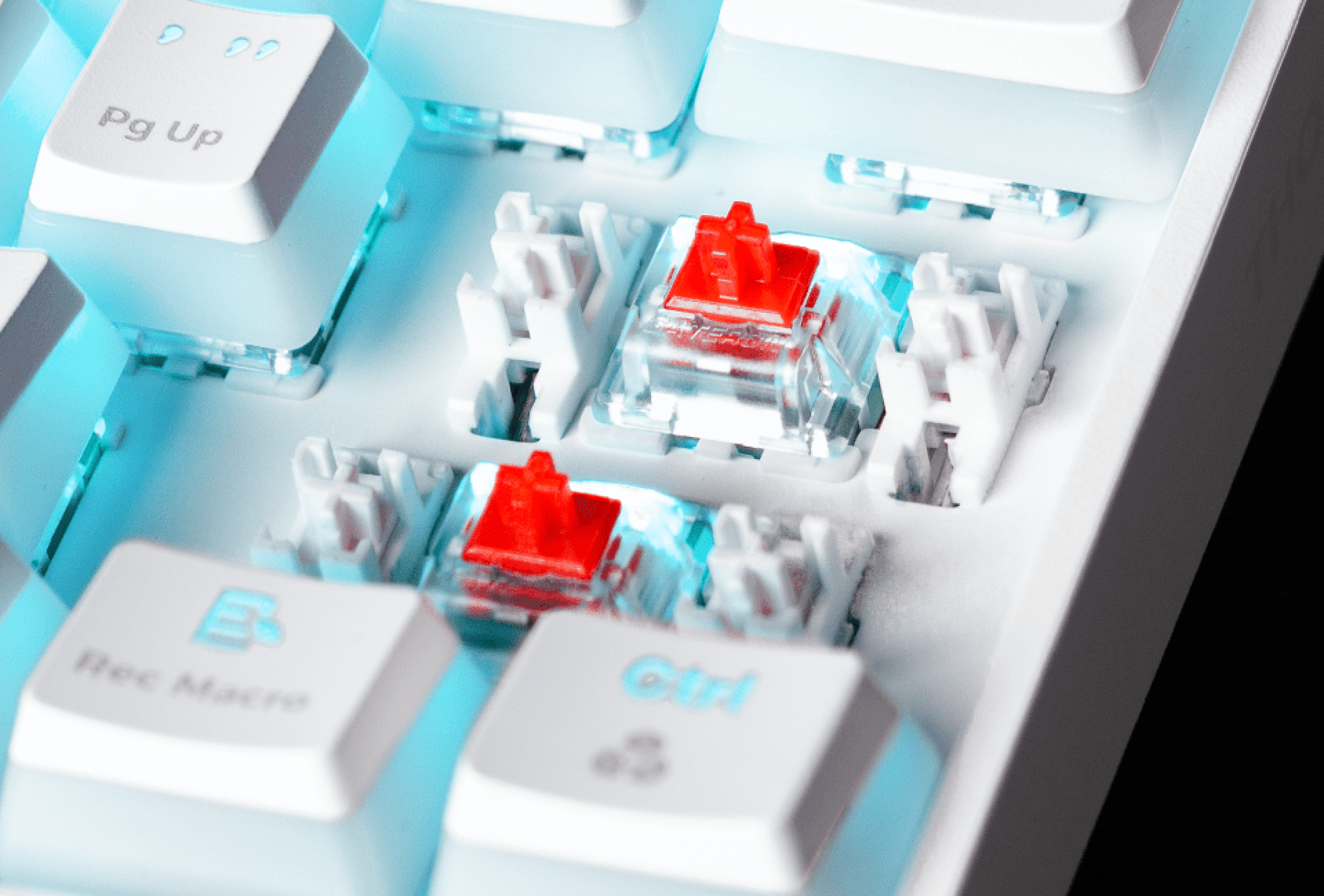 Close-up of keyboard keys with red switches and glowing white lighting underneath.