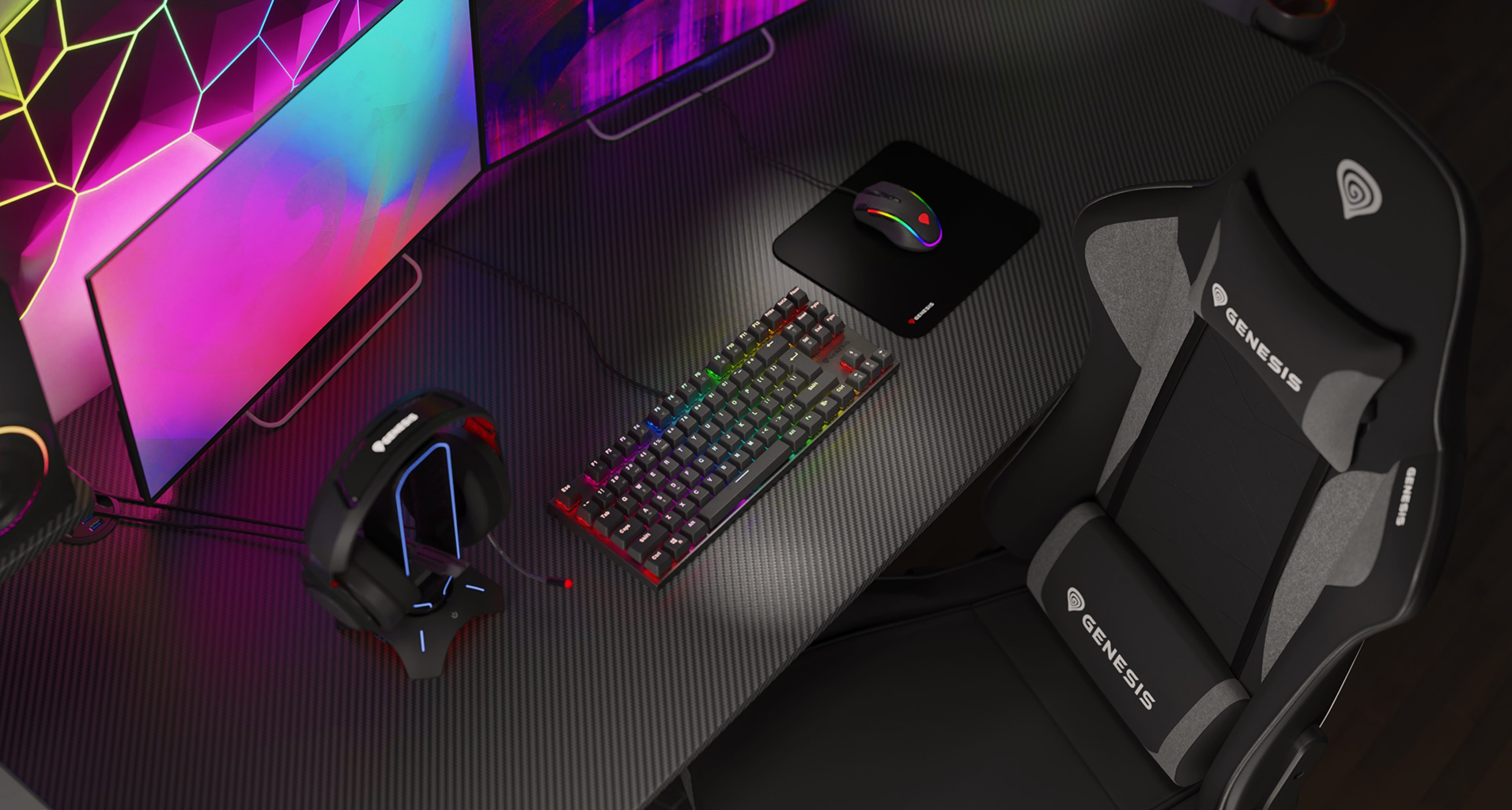 Gaming chair Genesis Nitro 440 G2 in black and gray, with a colorful keyboard, mousepad, headset, and vibrant monitors in the background