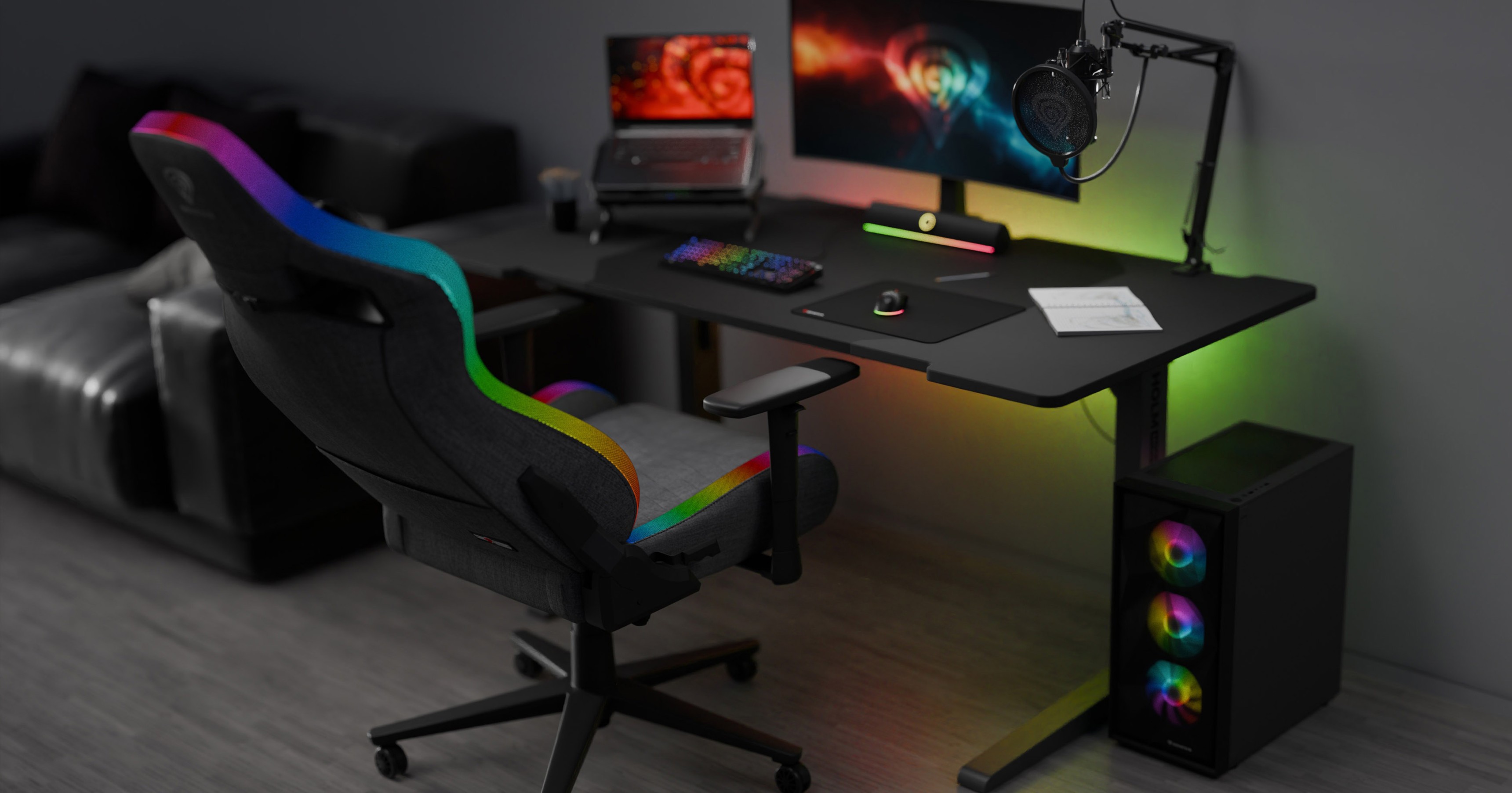 Gray gaming chair with RGB lighting, positioned beside a sleek gaming desk, monitor, microphone, and gaming accessories
