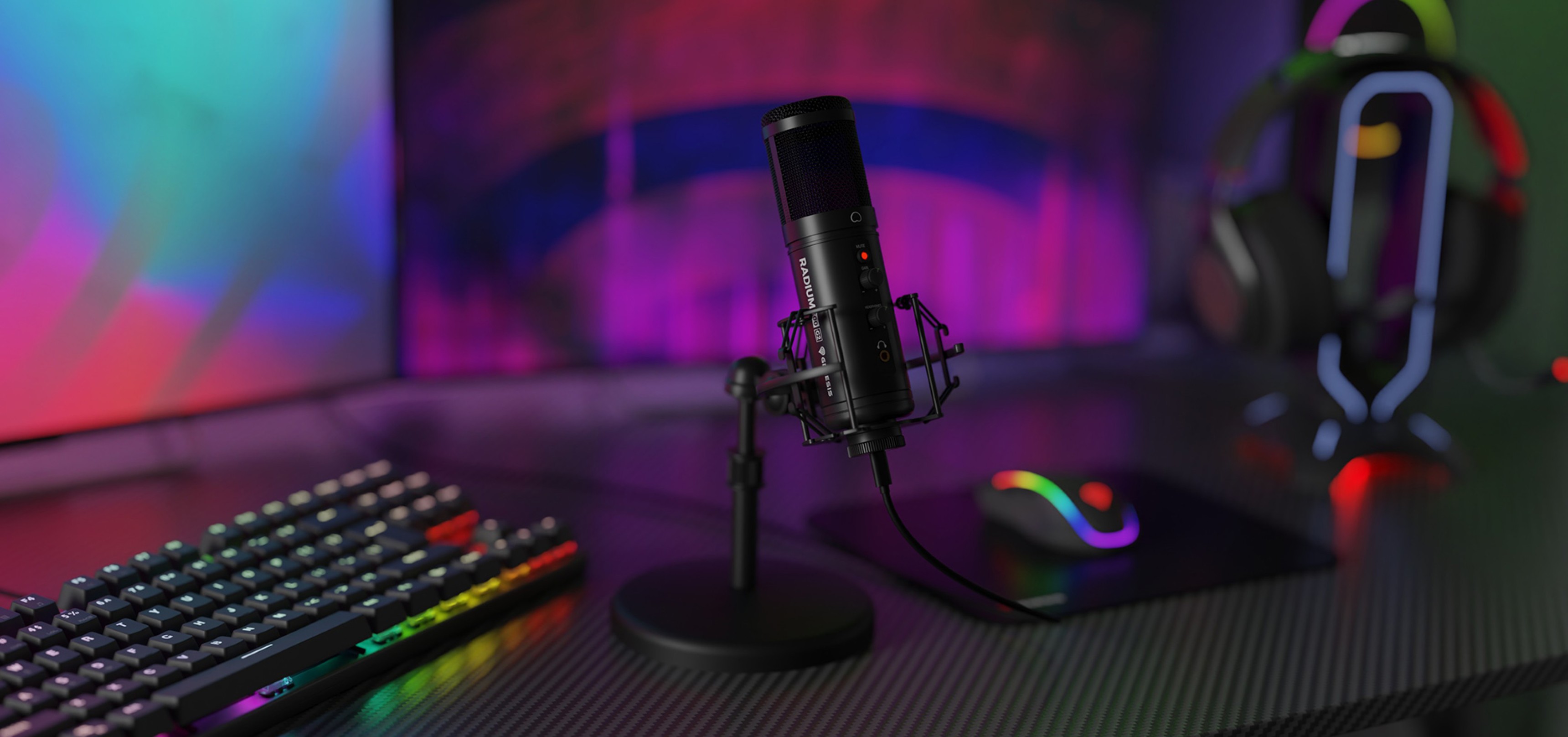 USB condenser microphone on a desk with RGB lighting, accompanied by a keyboard and gaming mouse