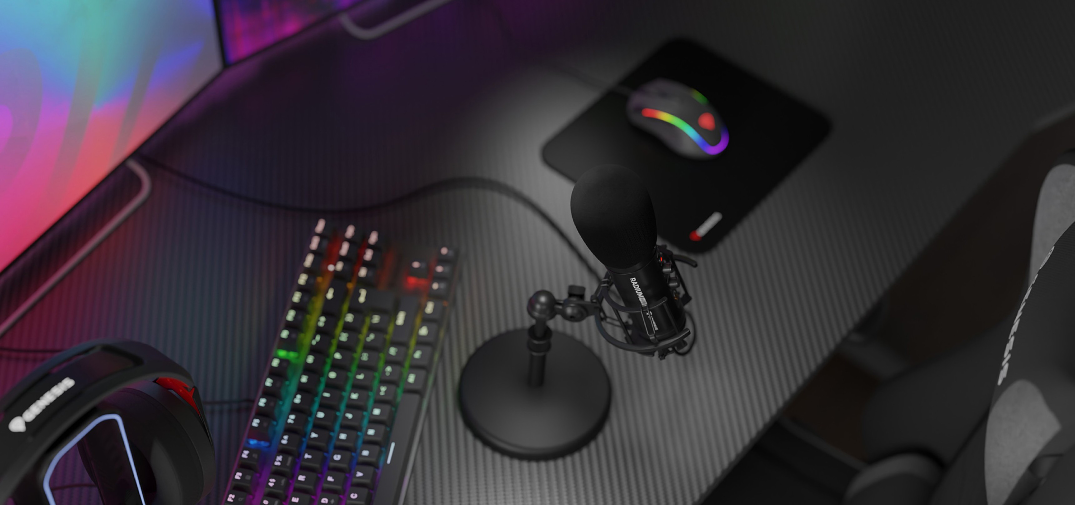 Stylish USB microphone on a carbon-textured desk with a colorful keyboard, mouse pad, and gaming headset