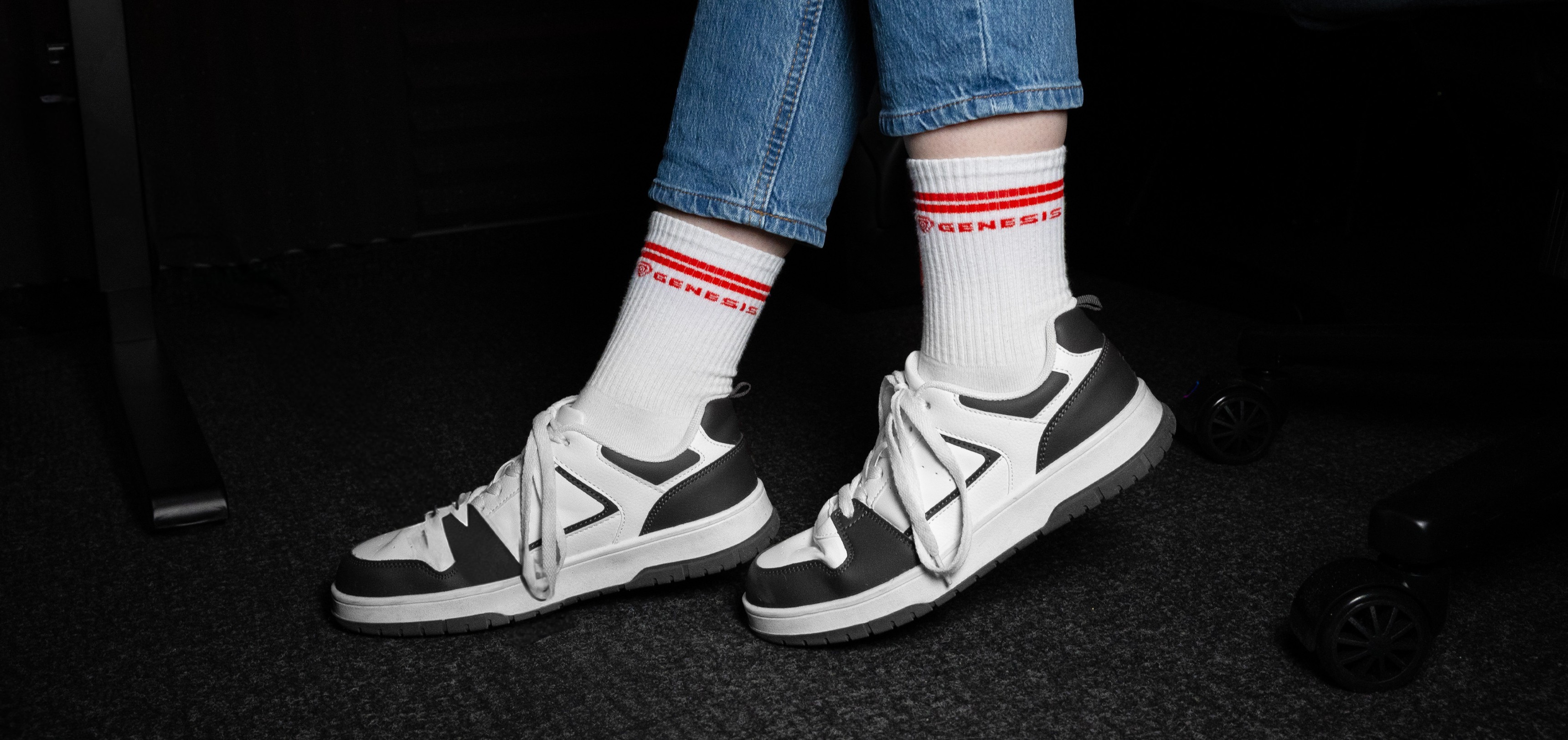 Sport socks in white with red stripes, paired with grey and white sneakers and blue jeans