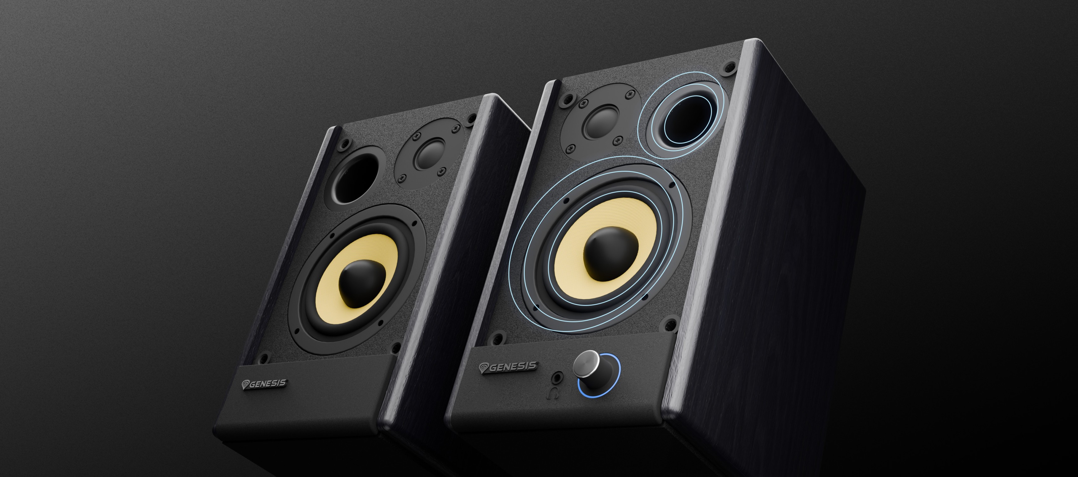 Two black audio speakers with yellow cones and a volume knob on one speaker.