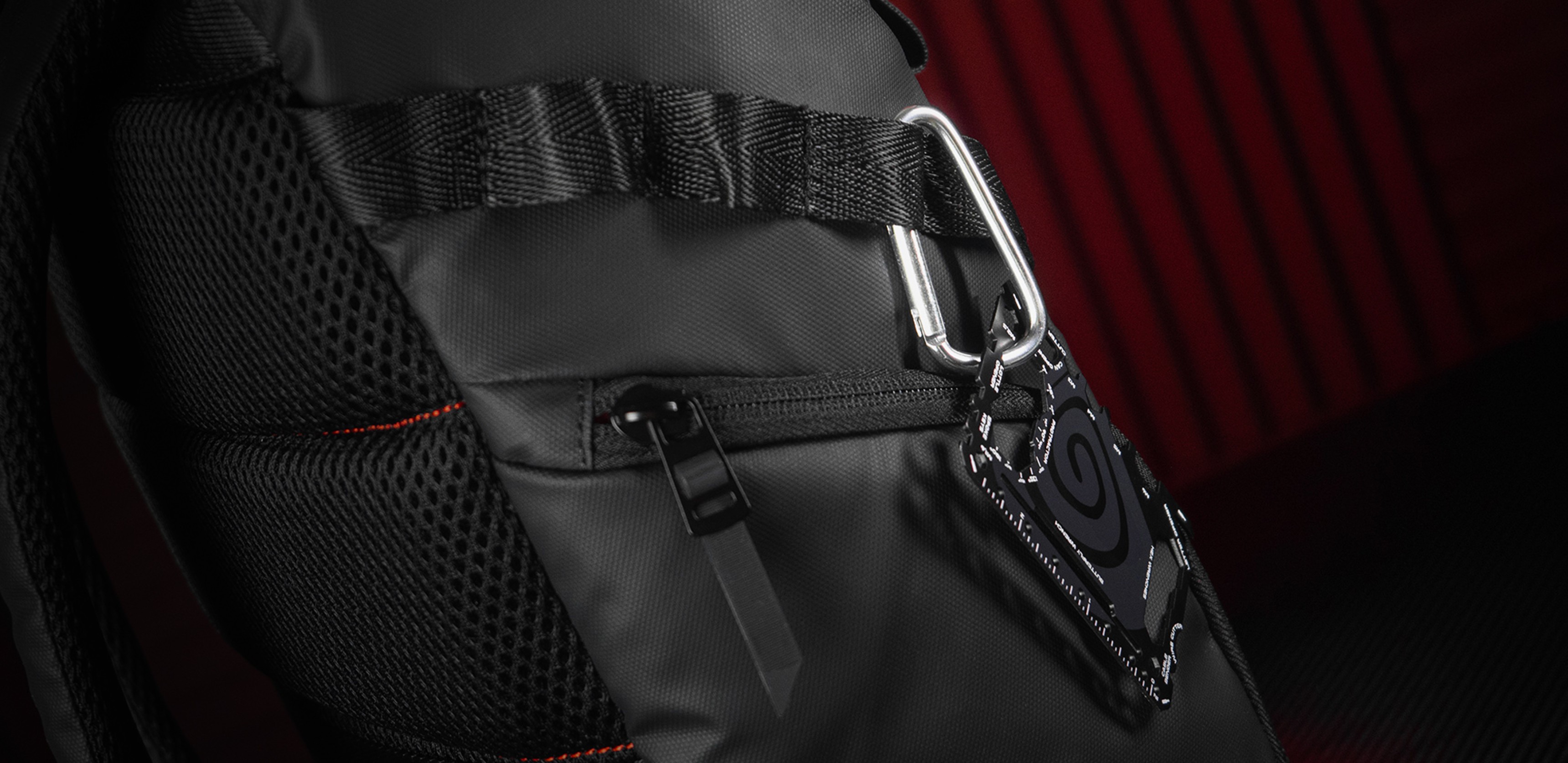Black laptop backpack with mesh detailing and a clip attached to the side, designed for 15.6" laptops, features 18L capacity