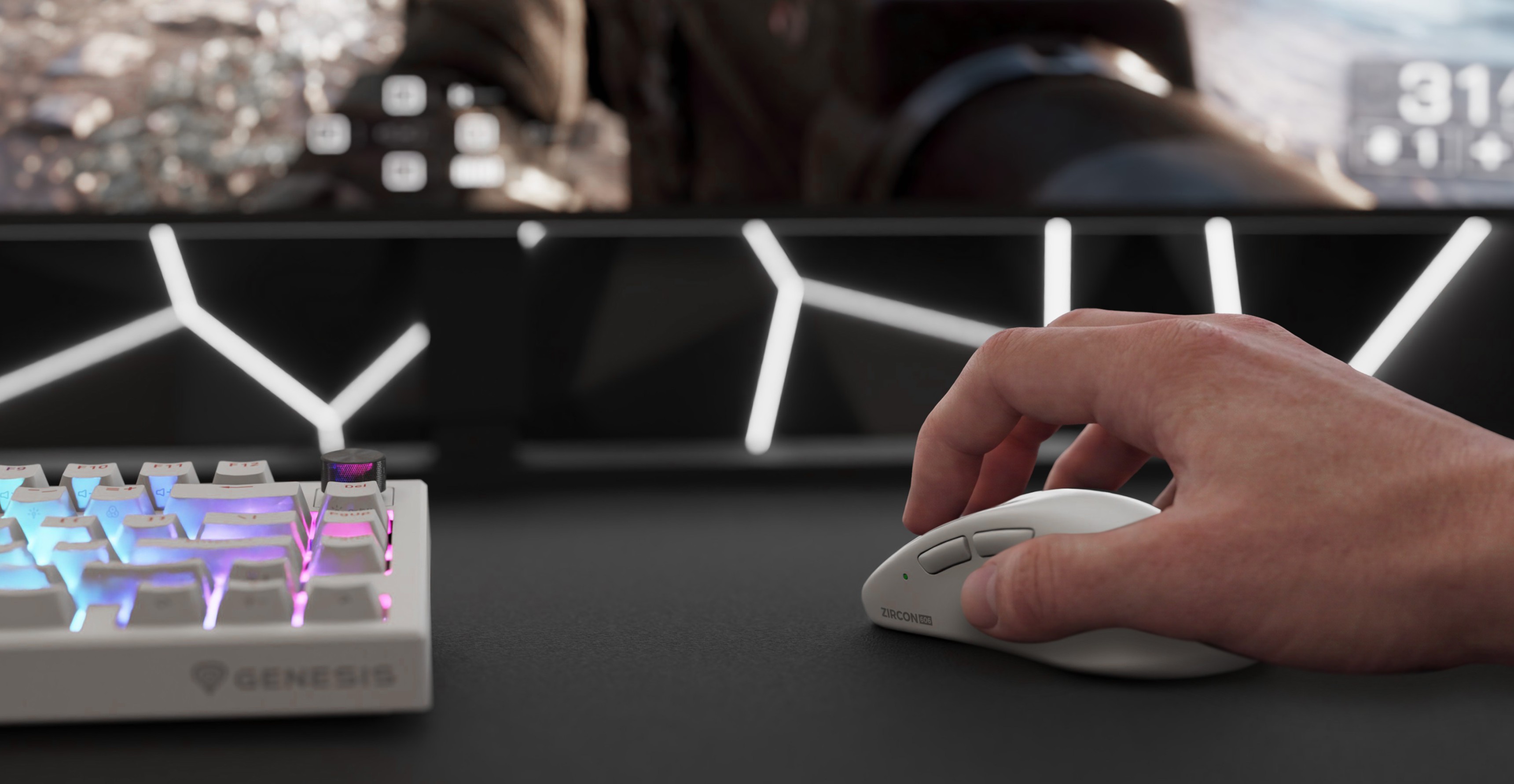 A hand using a computer mouse next to a keyboard with colored lights and a monitor in the background.