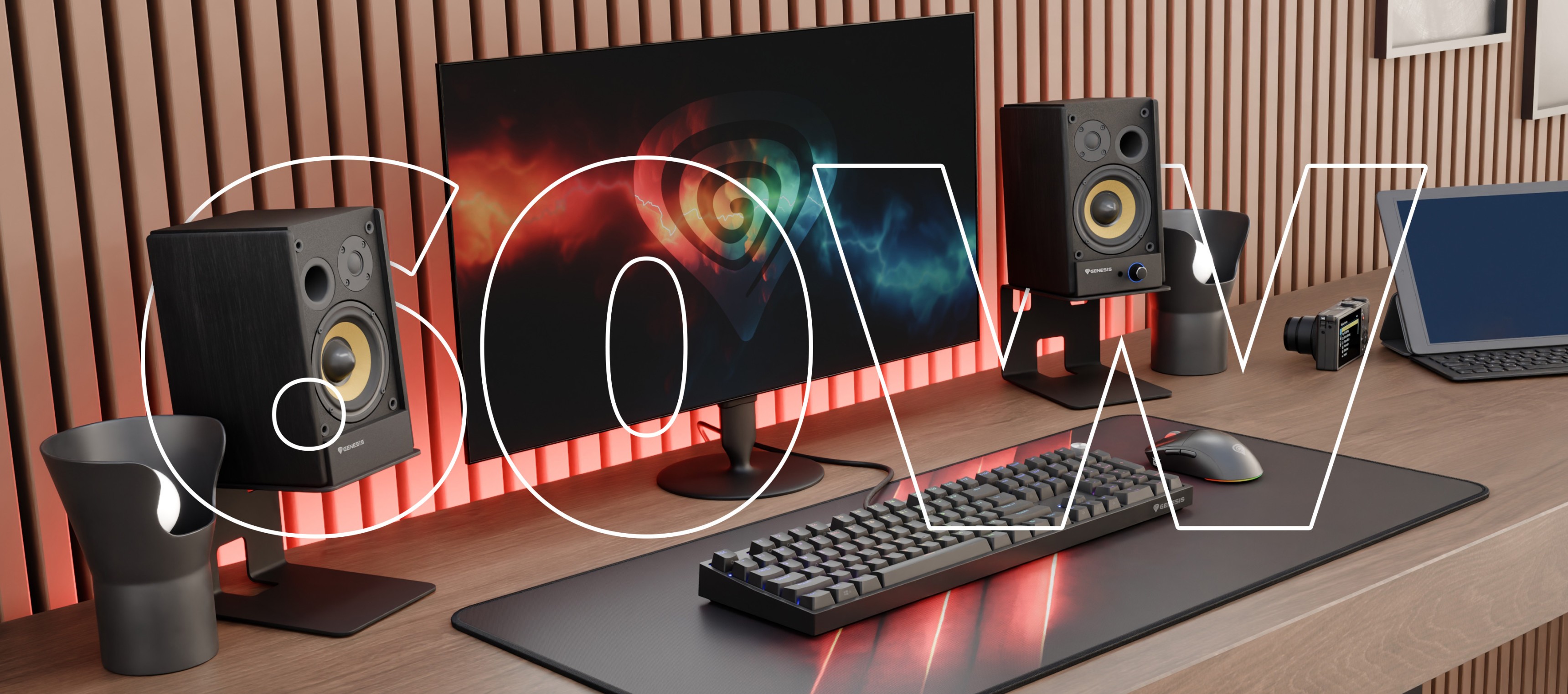 Modern workspace featuring a monitor, speakers, keyboard, and a camera on a wooden desk.