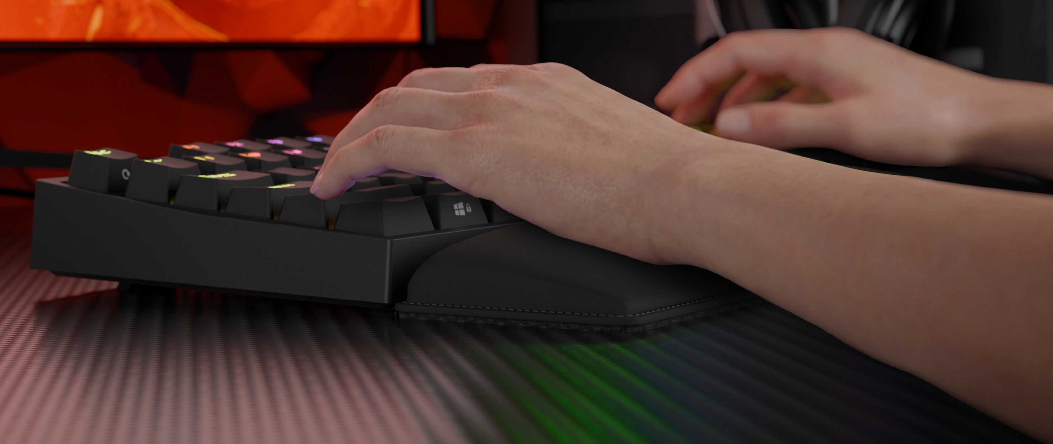 A hand is resting on a keyboard with colorful keys and a soft wrist support.